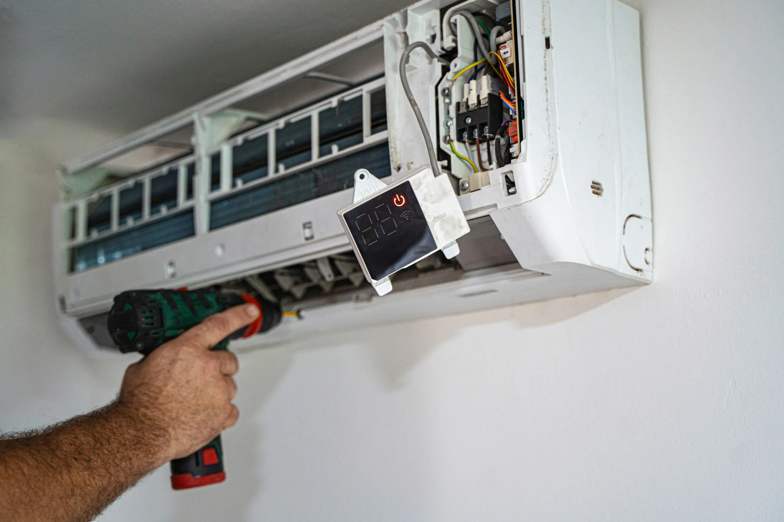 Technician mounting a ductless mini-split indoor unit on a wall